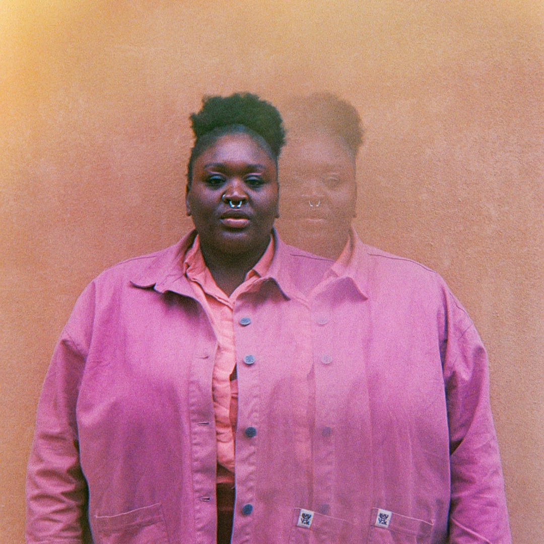 Portrait of Aka Kelzz in a colourful pink jacket. The image is grainy and blurry, showing the artist twice.